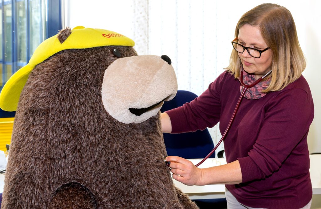 Medizinische Leistungen: Maskottchen Grömel in der Ostseeklinik Grömitz: Eine Ärztin demonstriert eine Untersuchung am Plüschbären für Kinder. Diagnostik gehört mit zu den medizinischen Leitungen der Klinik.