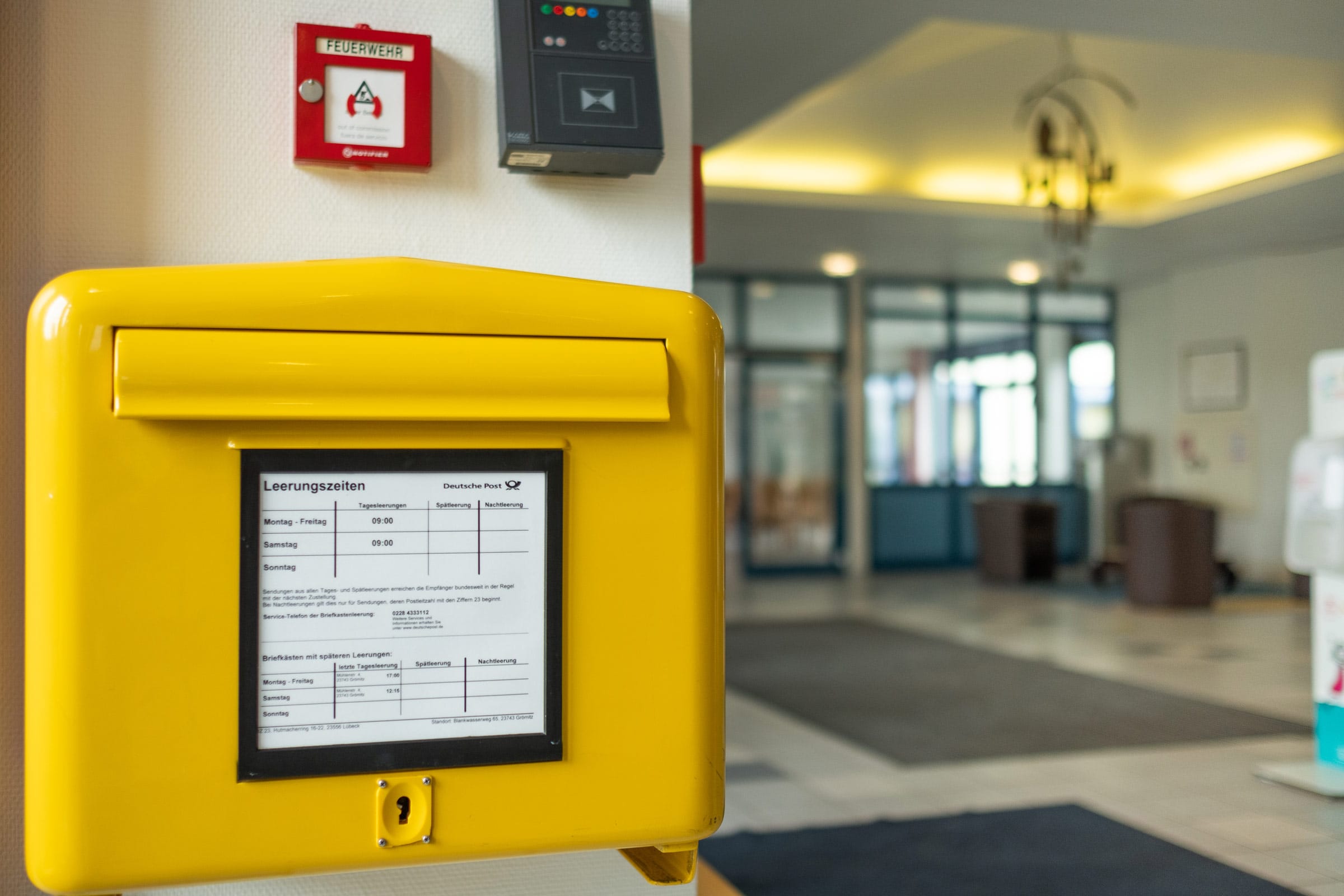 Ein gelber Briefkasten im Innenbereich der Ostseeklinik Grömitz als Symbol für Kontakt.